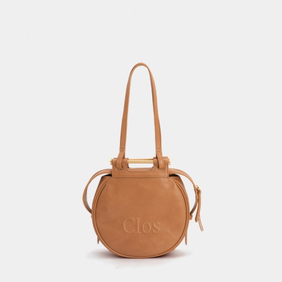 Crossbody bag on one shoulder with a top layer of calfskin commuter tote